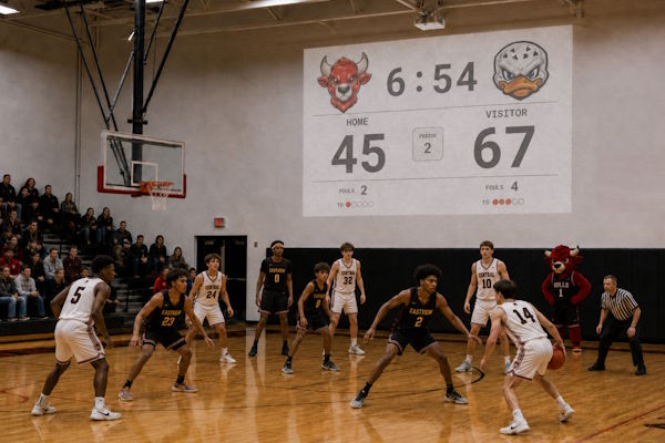 Basketball scoreboard projected onto a gym wall during a match
